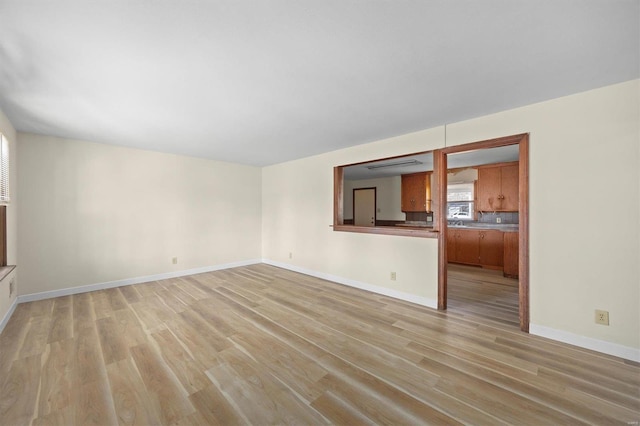 unfurnished living room with light wood-style floors and baseboards