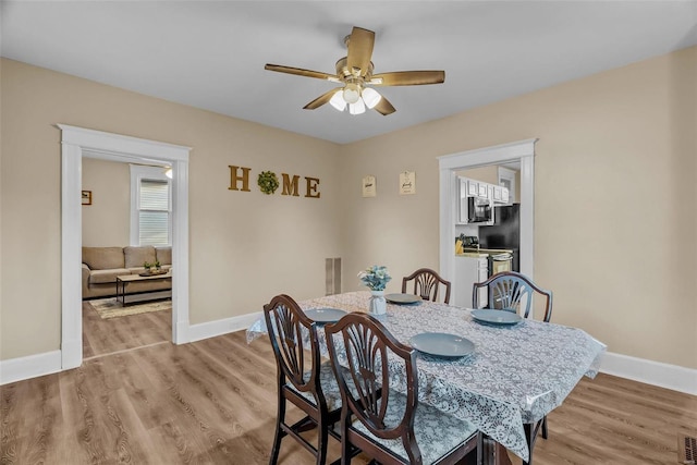 dining area with light hardwood / wood-style floors and ceiling fan