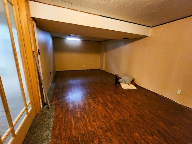 basement with dark hardwood / wood-style flooring