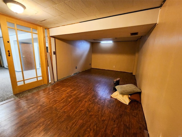 basement with dark hardwood / wood-style flooring