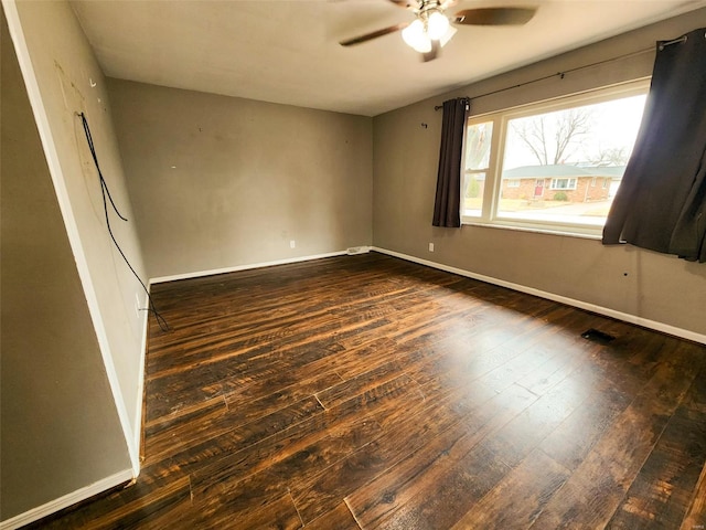 spare room featuring dark hardwood / wood-style flooring and ceiling fan