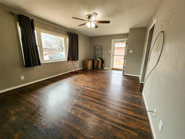 spare room featuring ceiling fan, dark wood-type flooring, and a wealth of natural light