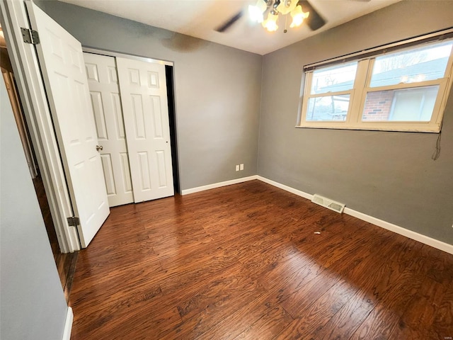 unfurnished bedroom featuring dark hardwood / wood-style flooring, a closet, and ceiling fan