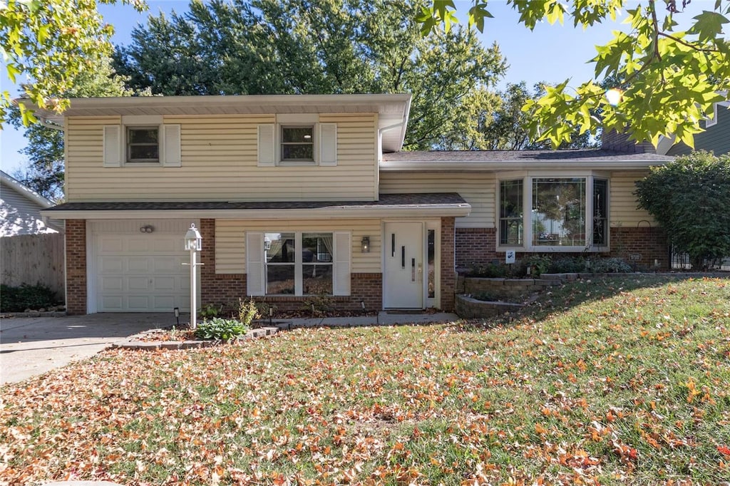 tri-level home with a front yard and a garage