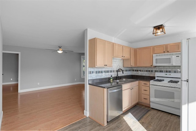 kitchen with light brown cabinetry, sink, hardwood / wood-style flooring, and white appliances