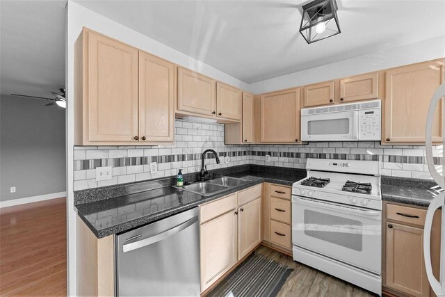 kitchen with light brown cabinetry, sink, white appliances, and dark hardwood / wood-style flooring