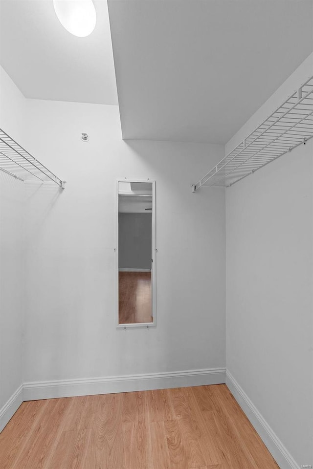 walk in closet with light hardwood / wood-style floors