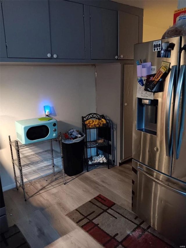 kitchen with stainless steel refrigerator with ice dispenser and hardwood / wood-style floors