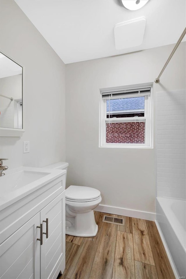 full bathroom featuring vanity, toilet, wood-type flooring, and bathing tub / shower combination