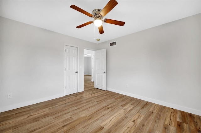 spare room with ceiling fan and light wood-type flooring