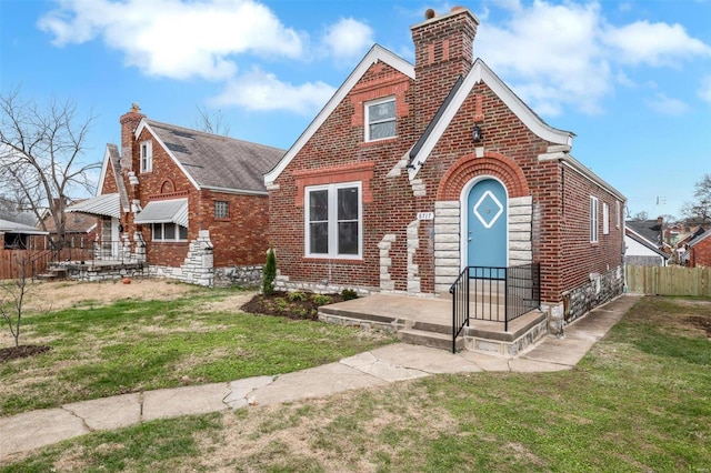 english style home featuring a front lawn