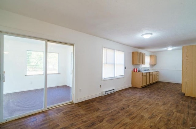 unfurnished living room featuring dark hardwood / wood-style flooring and baseboard heating