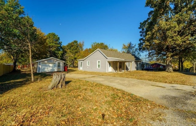 view of front of home with a front yard, a garage, and an outdoor structure