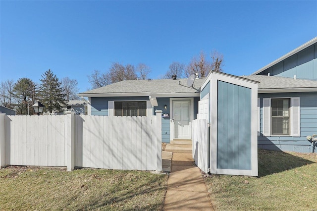 view of front of house with entry steps, fence, and a front yard