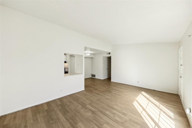 spare room with wood finished floors and visible vents