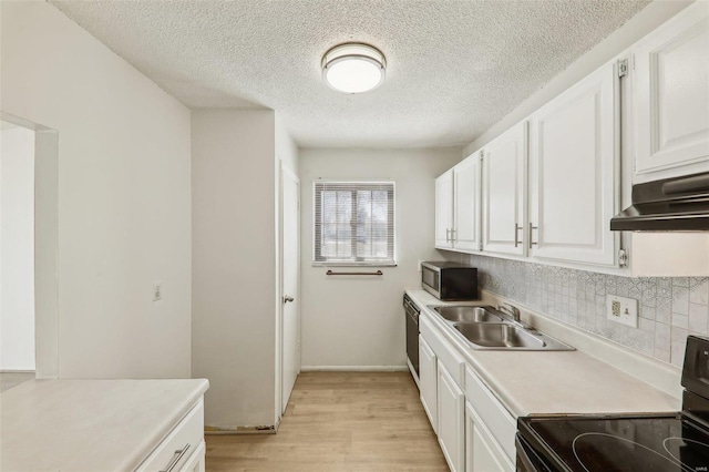 kitchen featuring electric range, a sink, white cabinetry, light wood finished floors, and stainless steel microwave