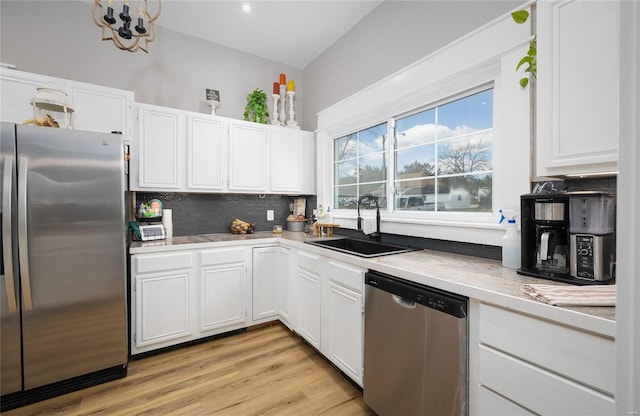 kitchen featuring white cabinetry, sink, tasteful backsplash, and stainless steel appliances