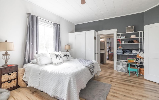 bedroom featuring ornamental molding, ceiling fan, and light wood-type flooring