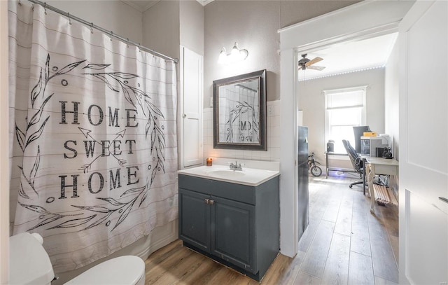 bathroom with hardwood / wood-style flooring, ceiling fan, vanity, and toilet