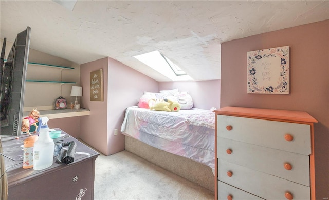 bedroom with vaulted ceiling with skylight and light carpet