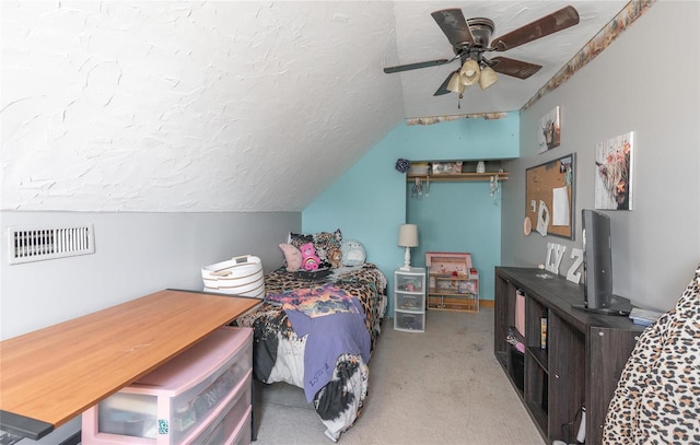 carpeted bedroom with vaulted ceiling, ceiling fan, and a textured ceiling