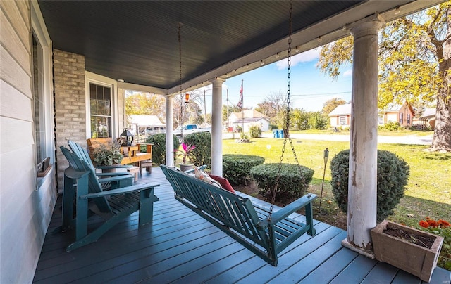 wooden deck with a yard and covered porch