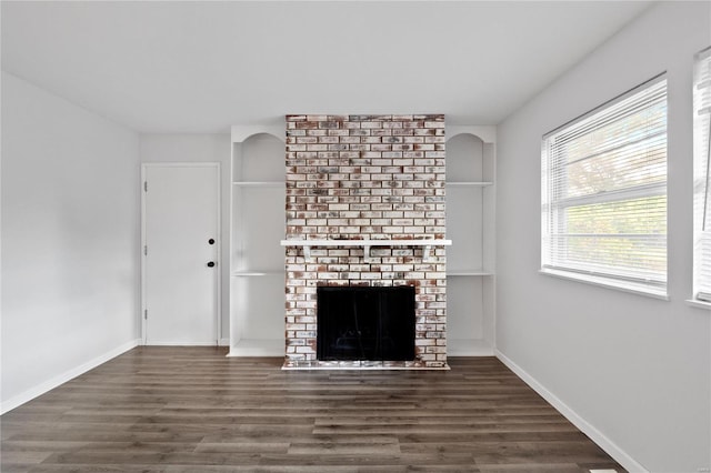 unfurnished living room featuring dark wood-type flooring and a fireplace