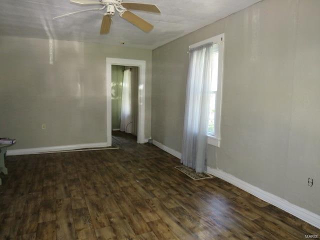 spare room featuring dark hardwood / wood-style floors, a healthy amount of sunlight, and ceiling fan