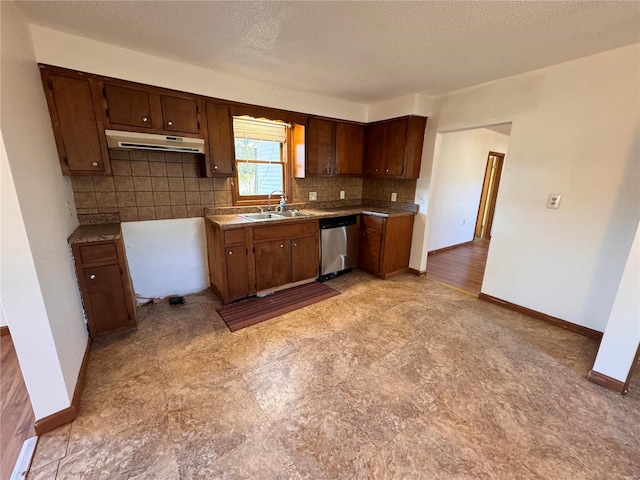 kitchen with a sink, dishwasher, backsplash, baseboards, and under cabinet range hood