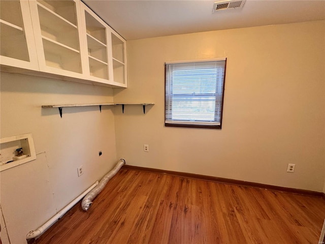 laundry room featuring visible vents, hookup for a washing machine, wood finished floors, electric dryer hookup, and laundry area