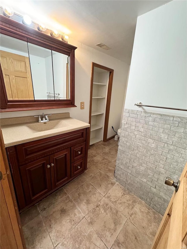bathroom featuring visible vents, toilet, and vanity