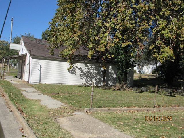 view of side of home featuring a garage and a lawn