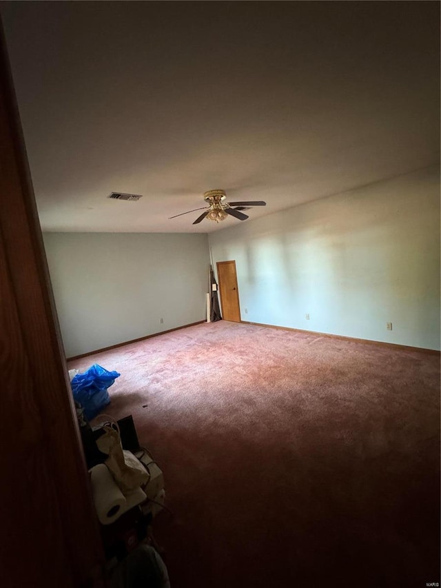 carpeted spare room featuring ceiling fan