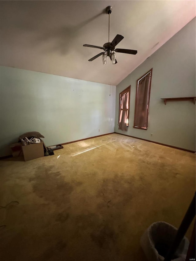 interior space featuring vaulted ceiling, carpet, and ceiling fan