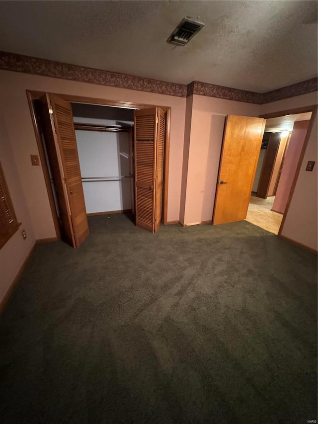 carpeted bedroom with a closet and a textured ceiling