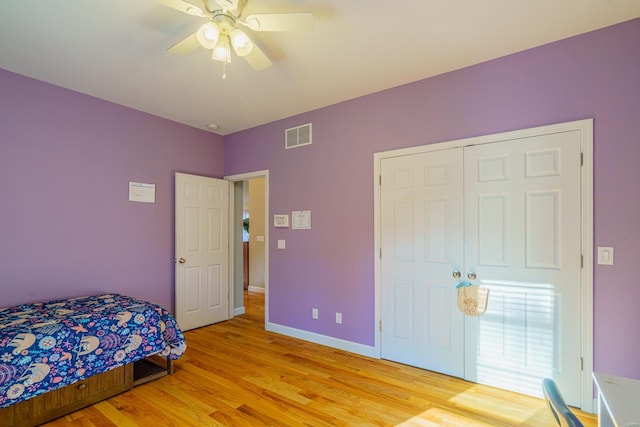 bedroom with a closet, light hardwood / wood-style floors, and ceiling fan