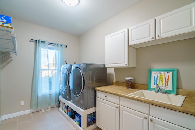 clothes washing area featuring light tile patterned floors, separate washer and dryer, and cabinets