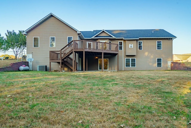 rear view of property featuring central AC, a wooden deck, and a lawn