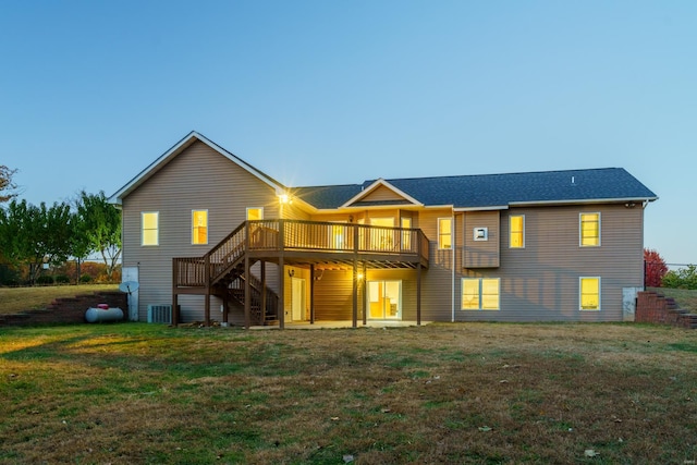 back of property featuring central air condition unit, a deck, and a lawn