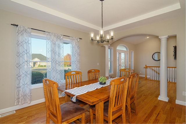 dining room featuring light hardwood / wood-style flooring, a tray ceiling, a wealth of natural light, and a chandelier