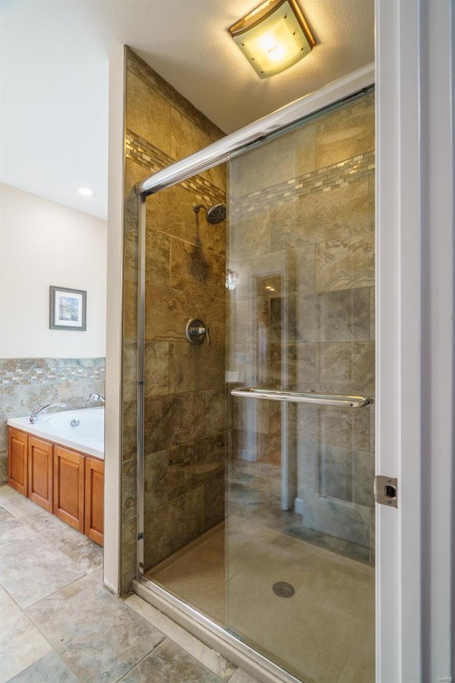 bathroom with separate shower and tub and a textured ceiling