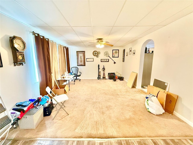 interior space featuring a paneled ceiling, hardwood / wood-style flooring, and ceiling fan