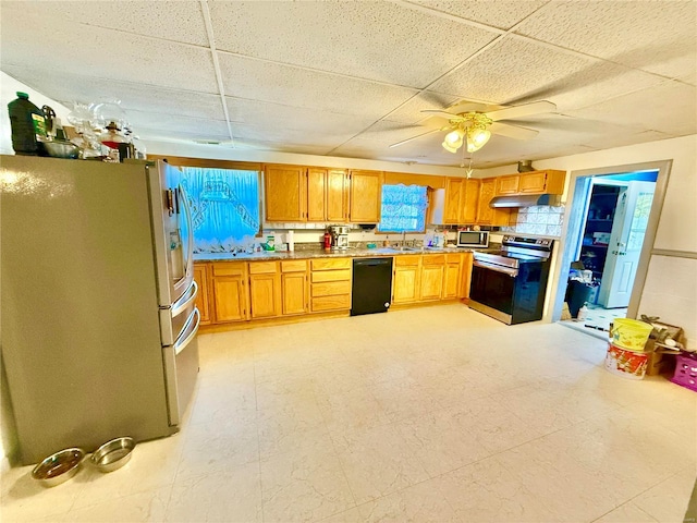 kitchen with appliances with stainless steel finishes, sink, ceiling fan, a paneled ceiling, and decorative backsplash