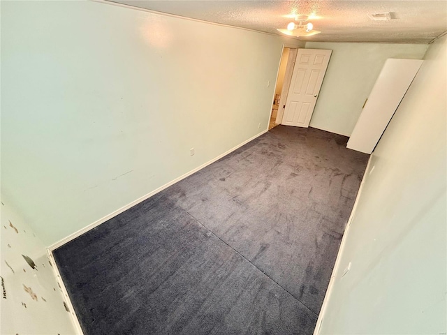 carpeted spare room with a textured ceiling