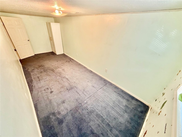 carpeted empty room with a textured ceiling