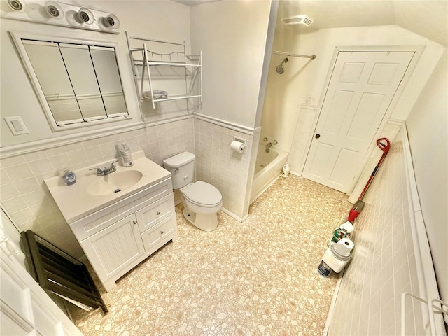 full bathroom with vanity, toilet, shower / bath combination, and tile walls