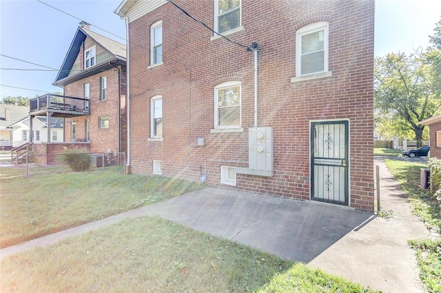 rear view of house featuring cooling unit, a patio area, and a yard