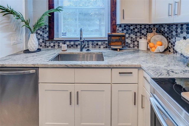 kitchen with appliances with stainless steel finishes, tasteful backsplash, white cabinetry, and sink