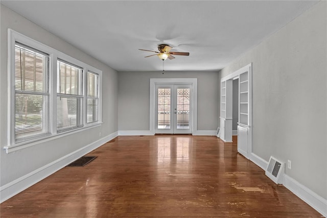 empty room with french doors, ceiling fan, and dark hardwood / wood-style flooring