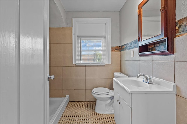 bathroom featuring toilet, walk in shower, vanity, and tile walls